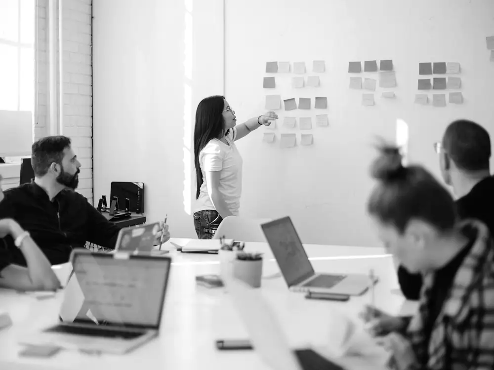 Sesión de trabajo con notas adhesivas pegadas en una pizarra blanca